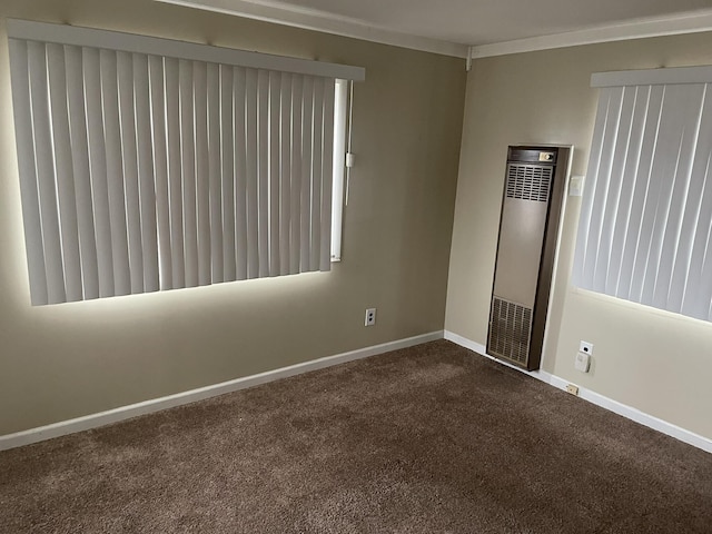 carpeted empty room featuring a heating unit and baseboards