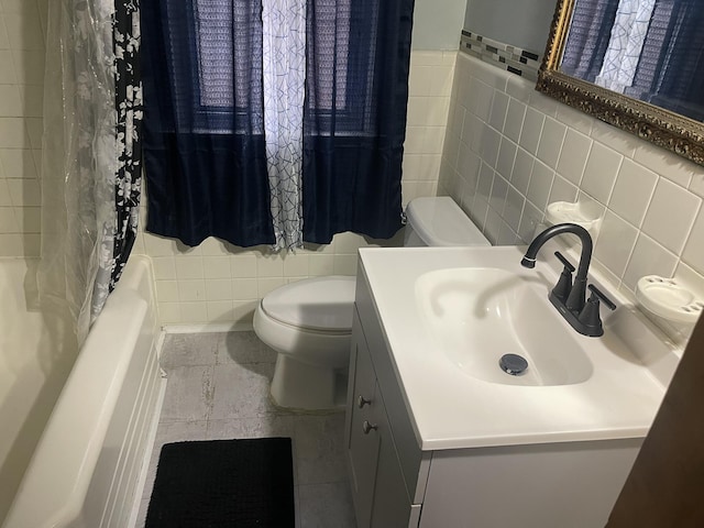 bathroom featuring toilet, shower / bathtub combination with curtain, tile walls, and vanity