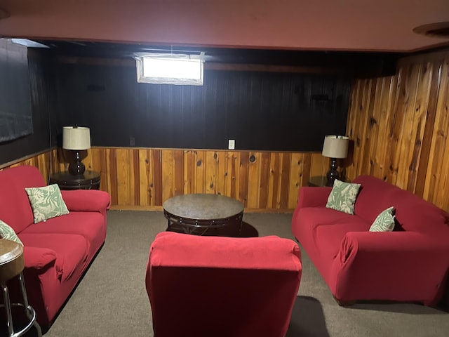 carpeted living room with wood walls