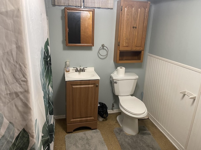 full bath with wainscoting, vanity, and toilet