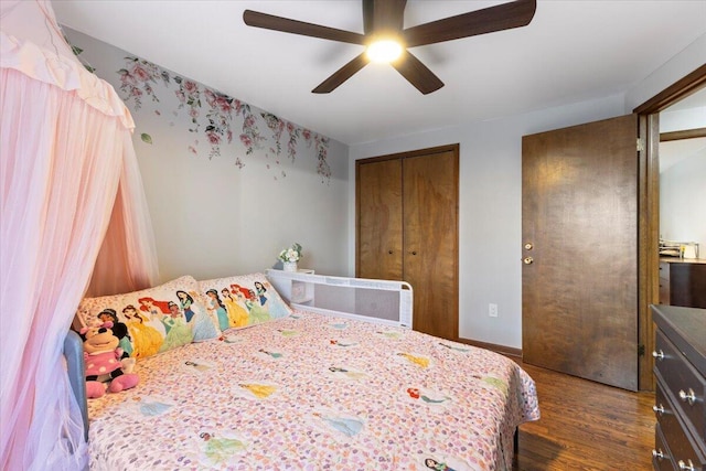 bedroom featuring dark wood-type flooring, a closet, and a ceiling fan