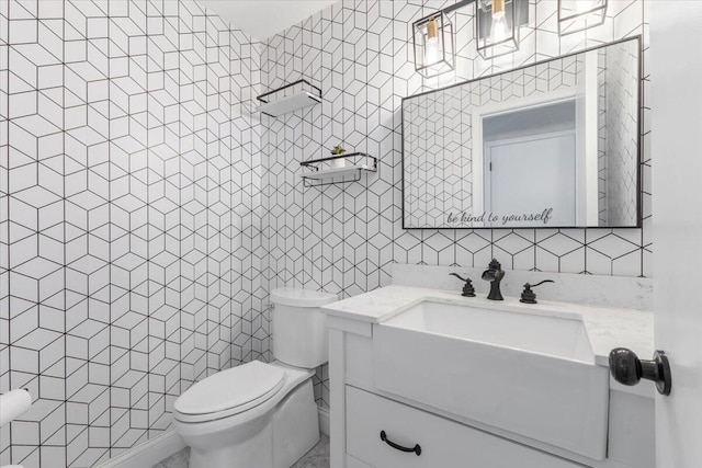 half bathroom featuring tile walls, vanity, and toilet