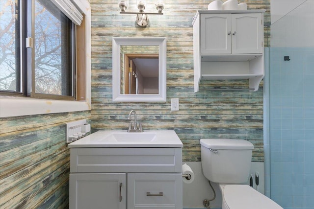 bathroom with vanity, toilet, and wallpapered walls