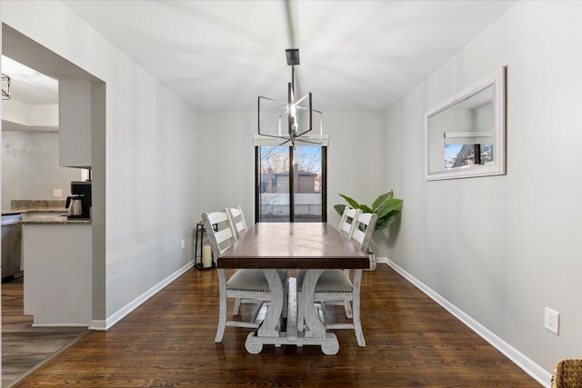 dining area featuring an inviting chandelier, baseboards, and dark wood-style flooring