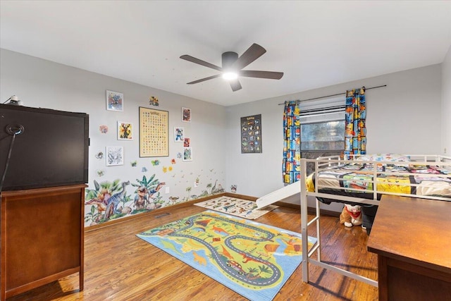 bedroom with a ceiling fan, baseboards, and wood finished floors