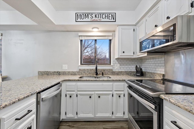 kitchen featuring appliances with stainless steel finishes, a sink, and white cabinets