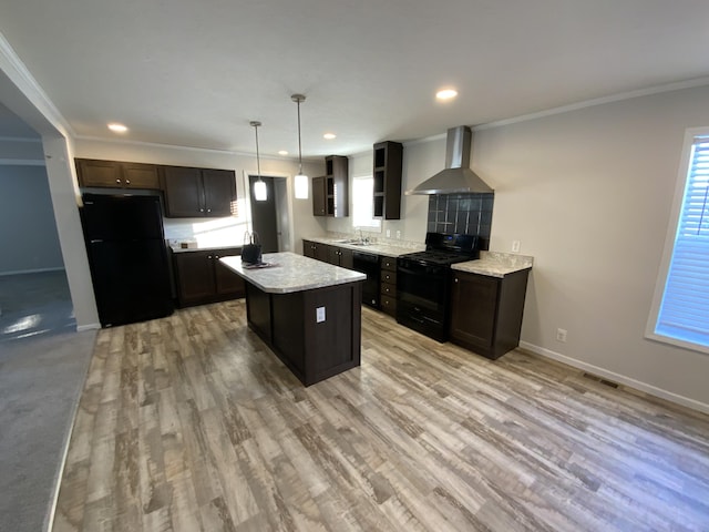 kitchen featuring light countertops, ornamental molding, wall chimney exhaust hood, black appliances, and pendant lighting