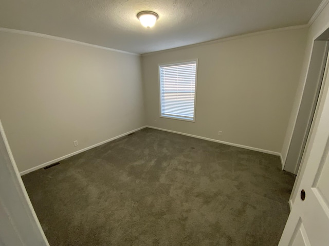 empty room featuring visible vents, ornamental molding, and baseboards