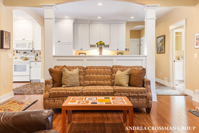 living room with recessed lighting, wood-type flooring, and ornate columns