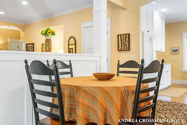 dining area with light wood-type flooring, ornate columns, ornamental molding, and recessed lighting