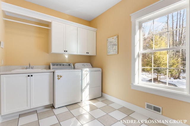 laundry area with washer and clothes dryer, visible vents, cabinet space, a healthy amount of sunlight, and a sink