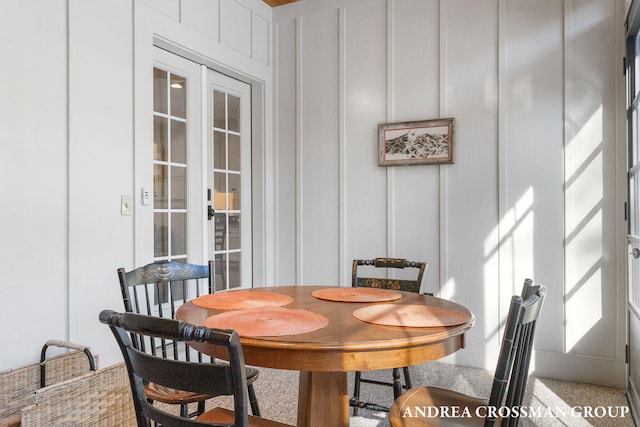 dining area featuring french doors and a decorative wall