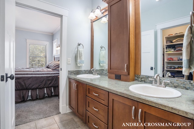 ensuite bathroom featuring tasteful backsplash, tile patterned floors, a sink, and ensuite bathroom