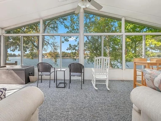 sunroom / solarium with a ceiling fan, a water view, and vaulted ceiling