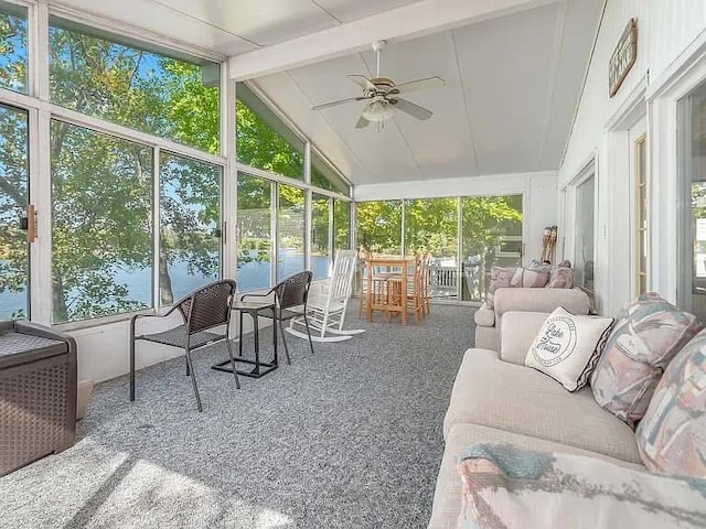 sunroom / solarium with lofted ceiling with beams, a water view, and a ceiling fan