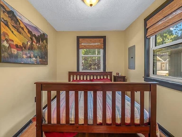 bedroom with a textured ceiling and baseboards