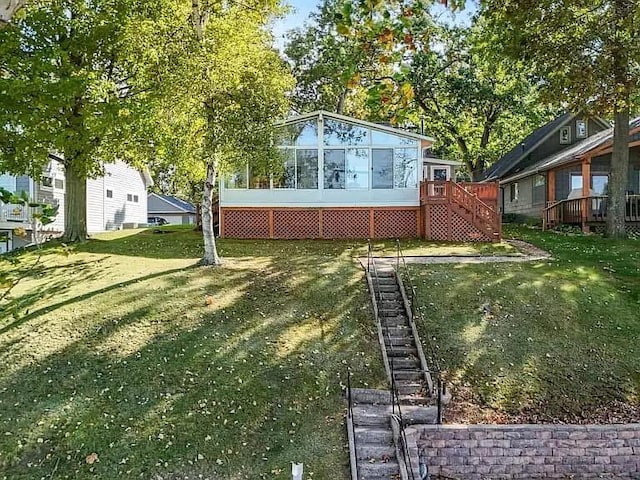 view of yard with stairs and a sunroom