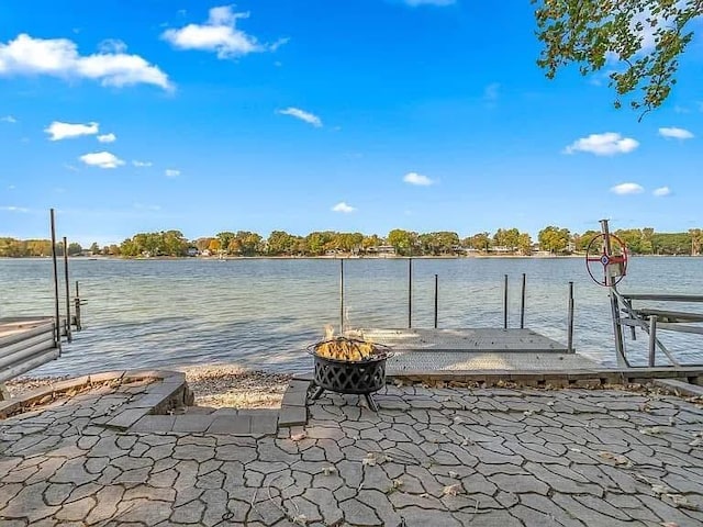 dock area with a water view and a fire pit