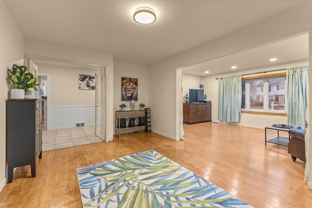 living room with recessed lighting, light wood-type flooring, visible vents, and baseboards