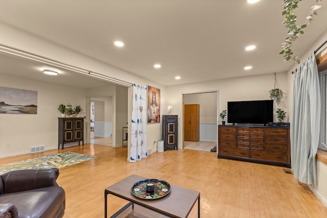 living area with light wood-type flooring, visible vents, and recessed lighting