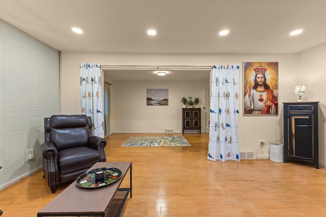 living area with recessed lighting, visible vents, and wood finished floors