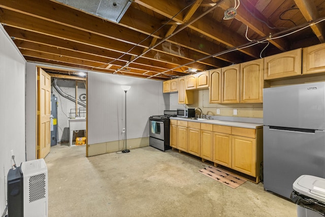 kitchen featuring unfinished concrete floors, appliances with stainless steel finishes, electric water heater, light countertops, and light brown cabinetry