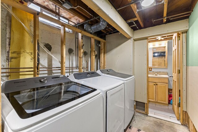 washroom with laundry area, a sink, and washer and dryer