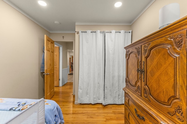 bedroom featuring light wood-type flooring, crown molding, and recessed lighting