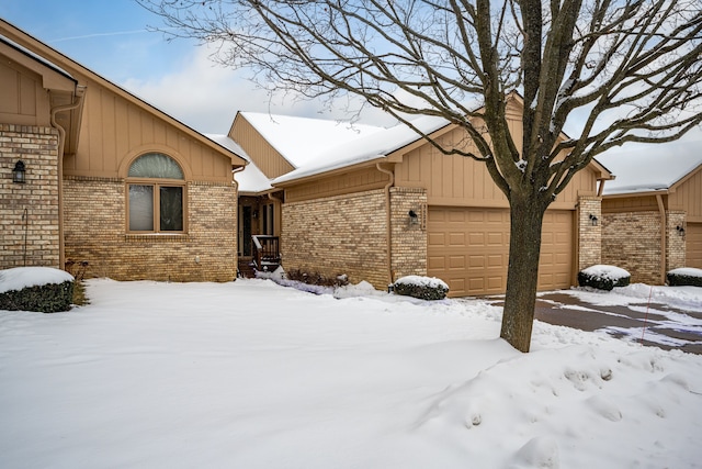 snowy yard featuring a garage