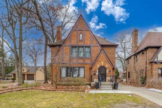 tudor-style house with brick siding and a chimney