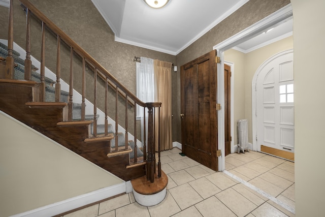 tiled foyer entrance with ornamental molding, baseboards, stairway, and radiator heating unit