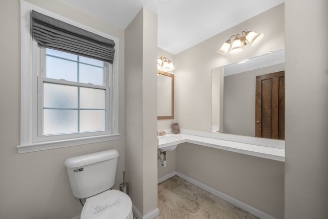 half bathroom featuring baseboards and toilet