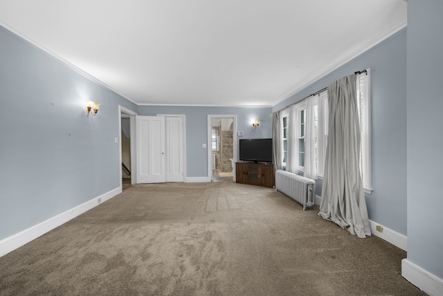 unfurnished living room with baseboards, crown molding, carpet, and radiator