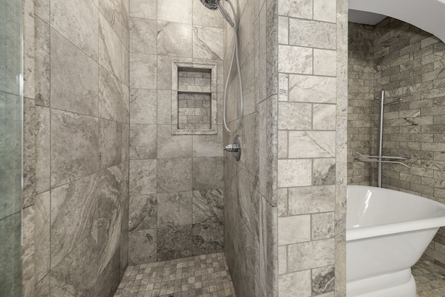 full bath featuring a soaking tub and a tile shower