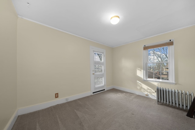 empty room with baseboards, radiator heating unit, carpet flooring, and crown molding