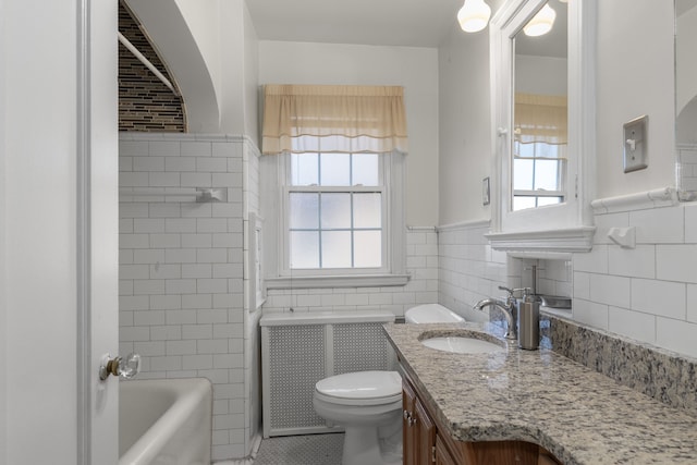 bathroom featuring a washtub, a wealth of natural light, tile walls, and toilet