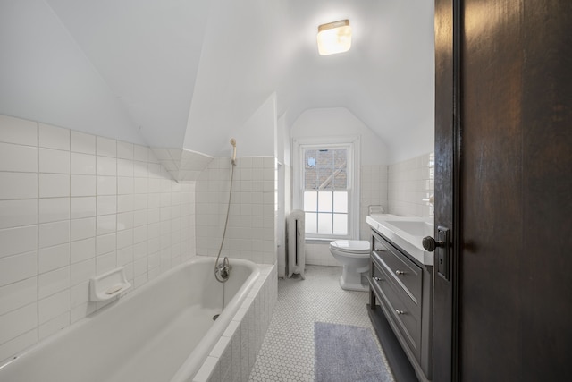 full bathroom featuring lofted ceiling, tile patterned flooring, toilet, vanity, and tile walls