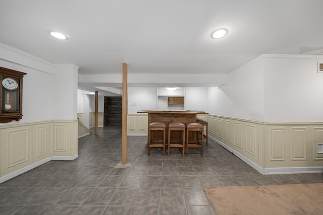 tiled dining space featuring visible vents, a wainscoted wall, bar, a decorative wall, and recessed lighting