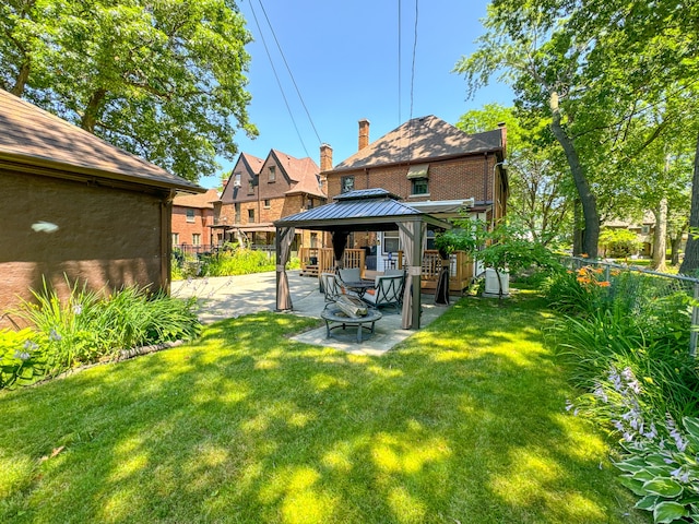 back of house with a gazebo, fence, a yard, a patio area, and brick siding