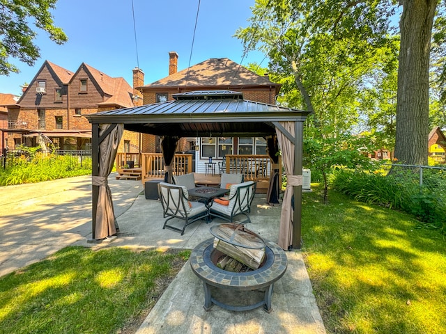 view of patio / terrace with fence, a fire pit, and a gazebo