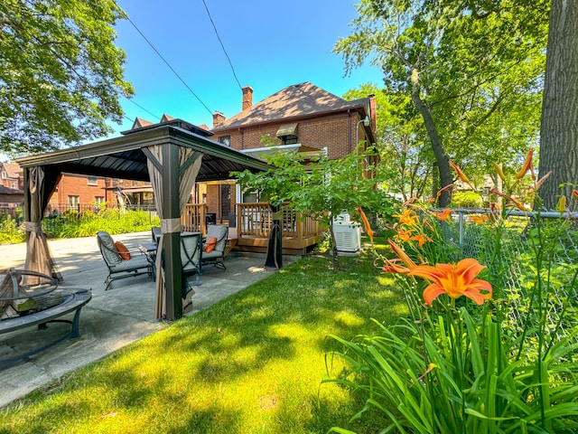 back of house with a patio, an outdoor fire pit, brick siding, fence, and a gazebo