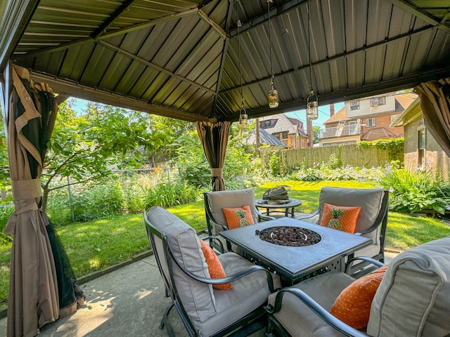 view of patio with an outdoor fire pit, fence, and a gazebo