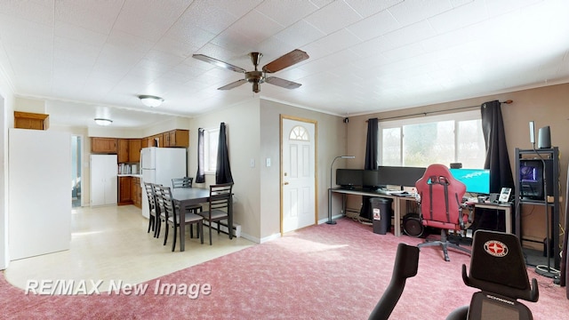 office featuring ceiling fan, baseboards, crown molding, and light colored carpet