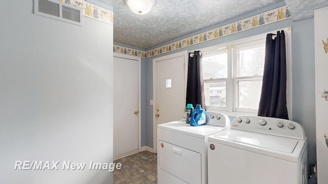 laundry room with a textured ceiling, laundry area, separate washer and dryer, visible vents, and baseboards