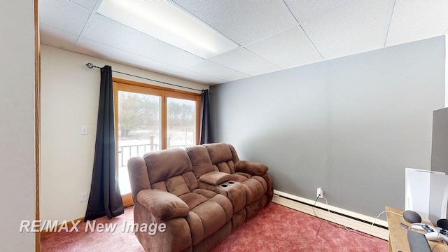 living room with a baseboard heating unit, carpet, a paneled ceiling, and baseboards