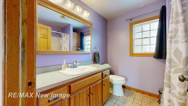 full bathroom featuring toilet, vanity, and baseboards