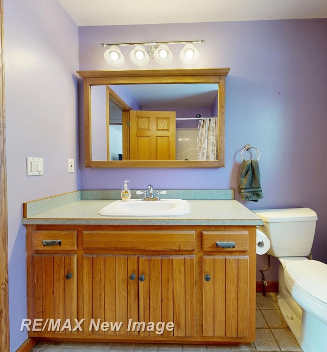 bathroom featuring tile patterned flooring, a shower with shower curtain, vanity, and toilet