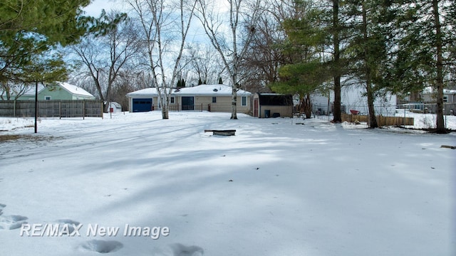 snowy yard featuring an outbuilding and fence