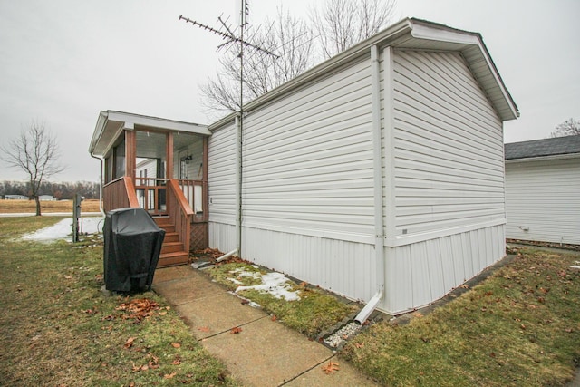 view of side of property featuring a sunroom and a yard