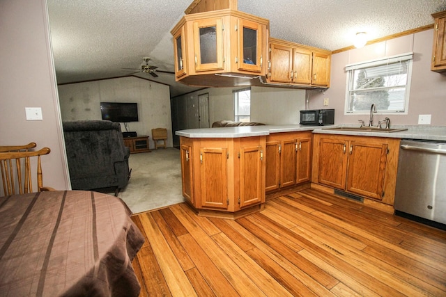 kitchen featuring light countertops, stainless steel dishwasher, glass insert cabinets, open floor plan, and a sink